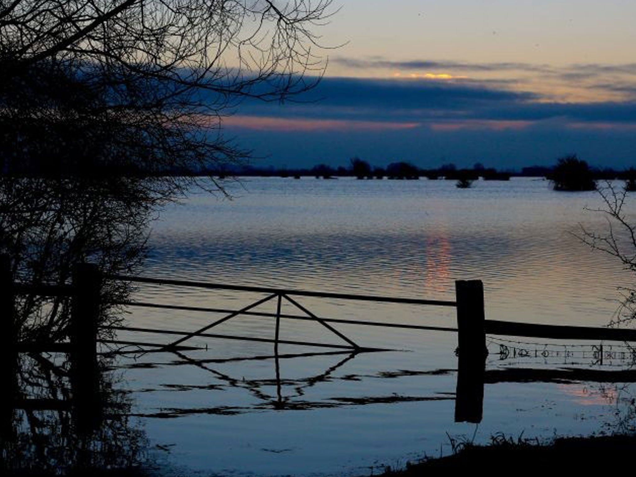The sun rises over flood water still present in fields on the Somerset Levels near Langport