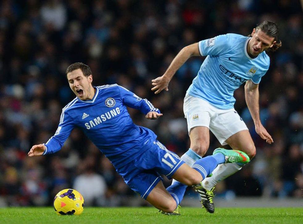 Chelsea’s Eden Hazard (left) comes off worse in an encounter with Martin Demichelis