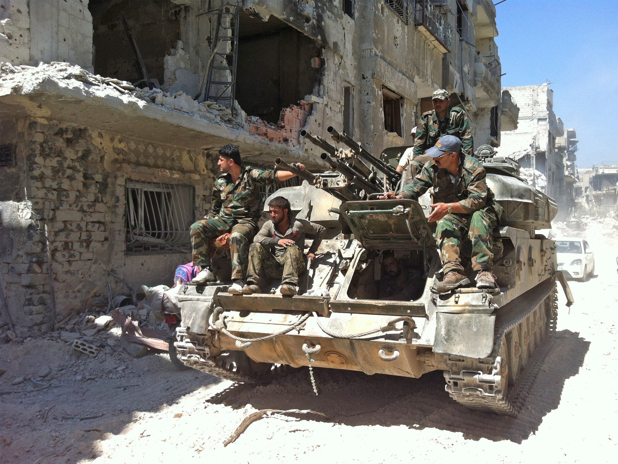 Syrian government forces on patrol in the devastated district of al-Khalidiyah (Getty)