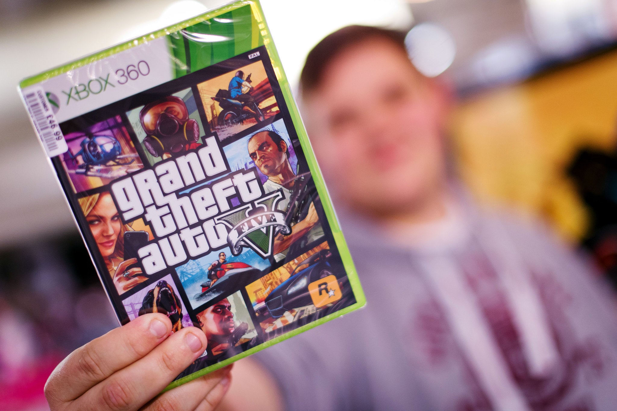 A gamer poses with his copy of the console game Grand Theft Auto 5 at the midnight opening of the 17 September, 2013.