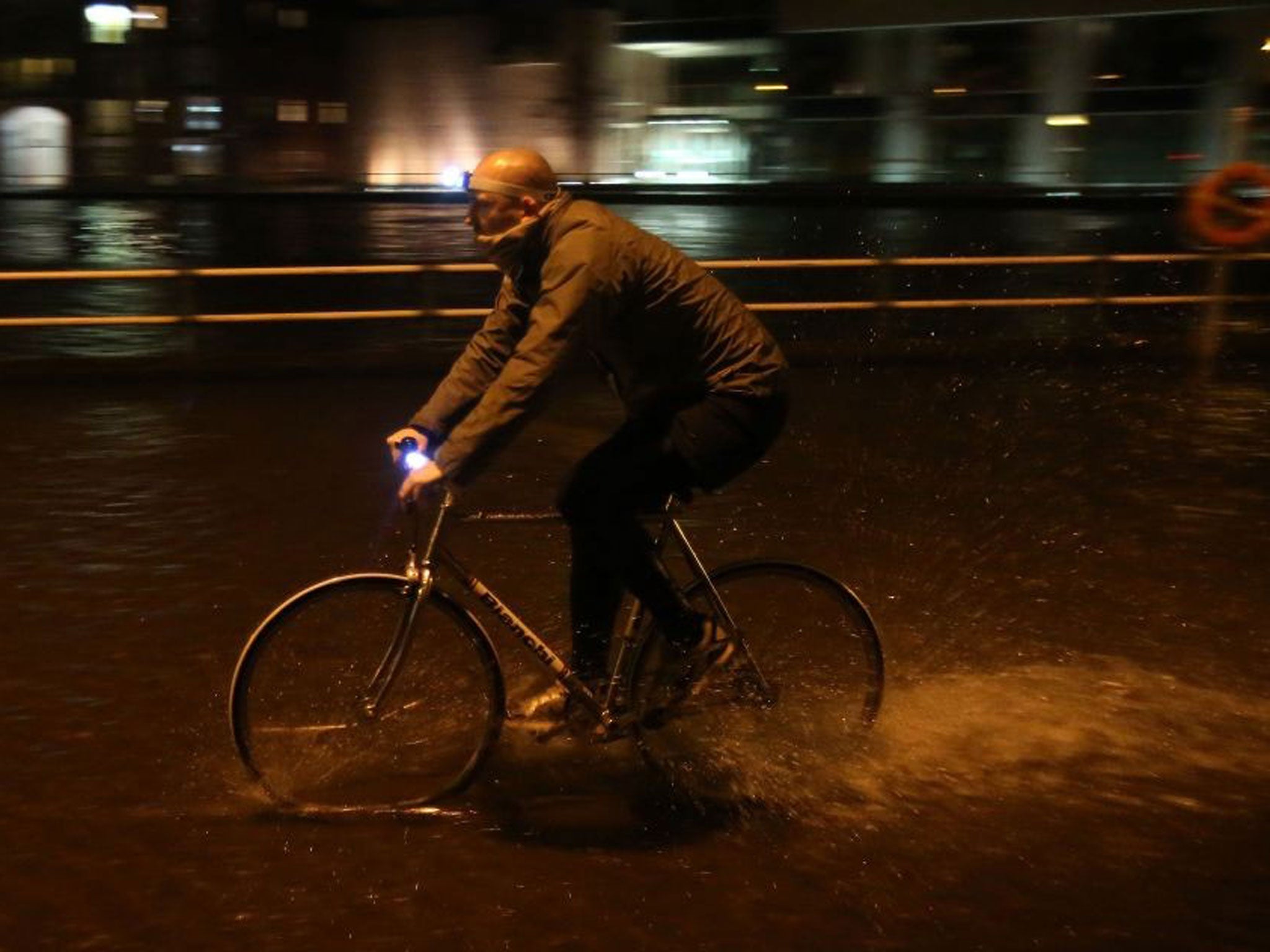 A man on a bike cycles through flood water in Cork city