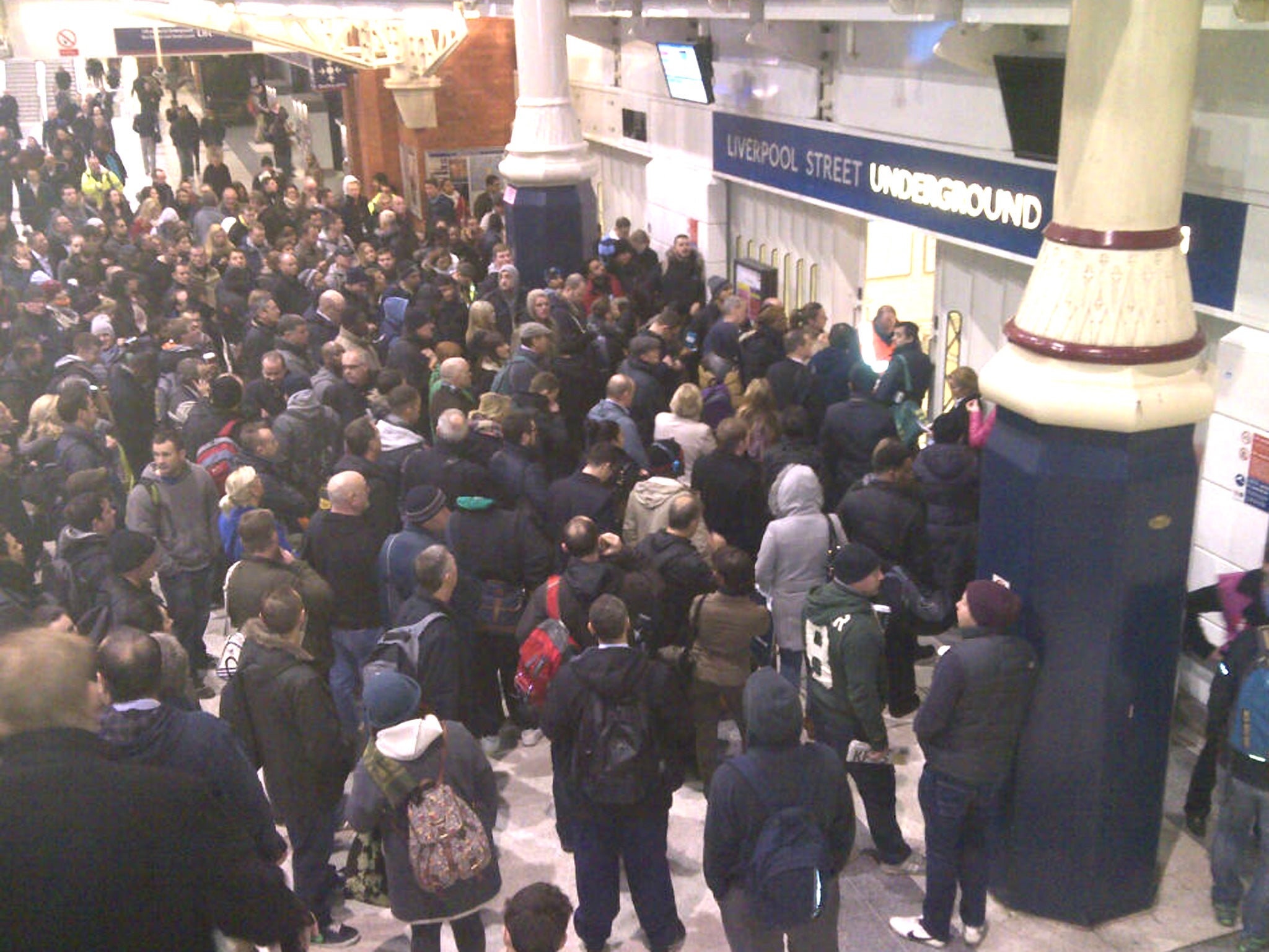 Crowds wait for the 7am opening of the restricted Tube lines at Liverpool Street