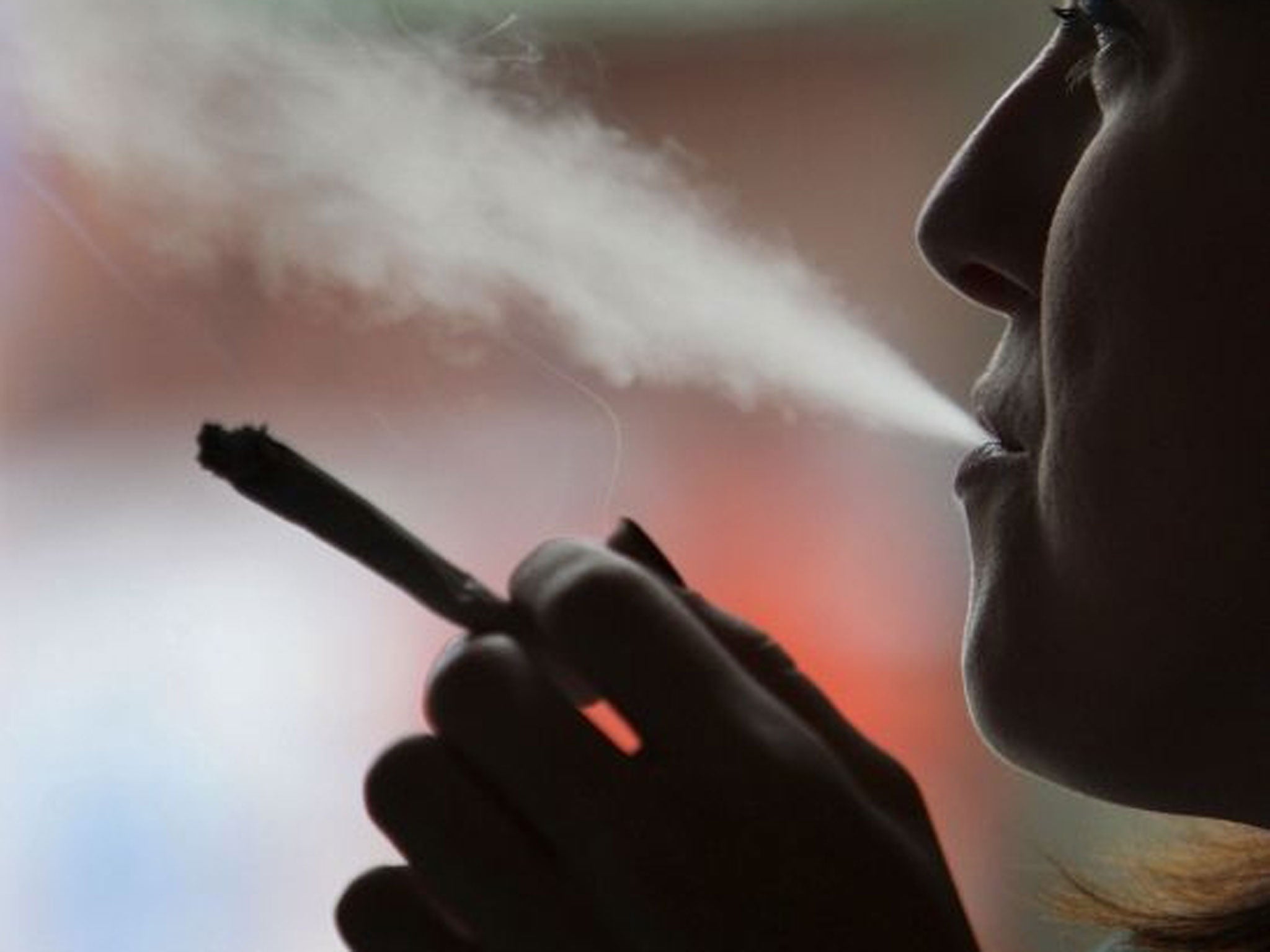 A woman smokes a cigarette. Experts hope that CVS has set a precedent that will help cut smoking in the US