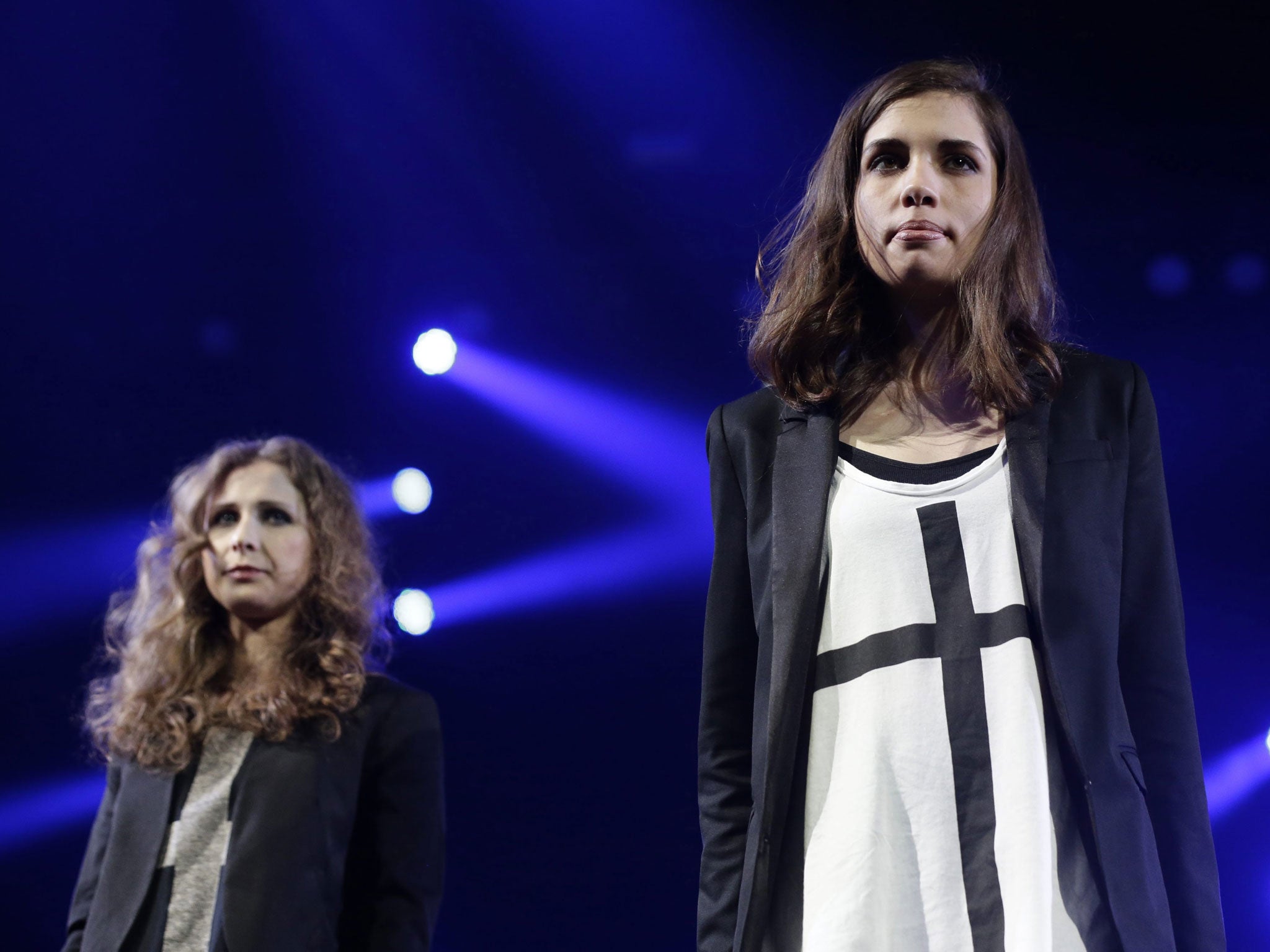 Maria Alyokhina (L) and Nadezhda Tolokonnikova (R) members of the Russian feminist punk rock protest group 'Pussy Riot' are seen on stage during the Amnesty International 'Bringing Human Rights Home' concert at the Barclays center in Brooklyn, New York, N