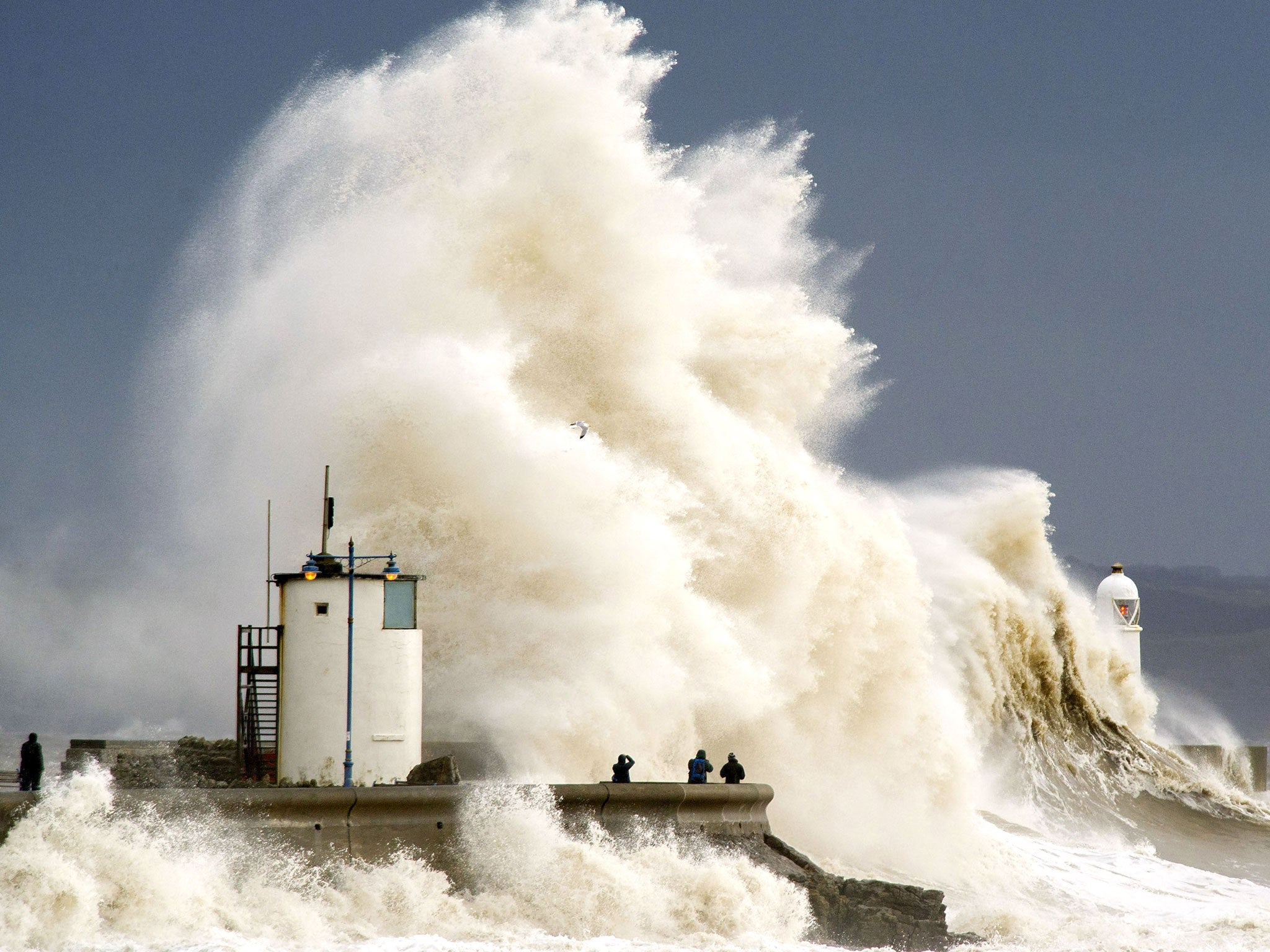Waves break over the harbour wall at Porthcawl during a high tide 