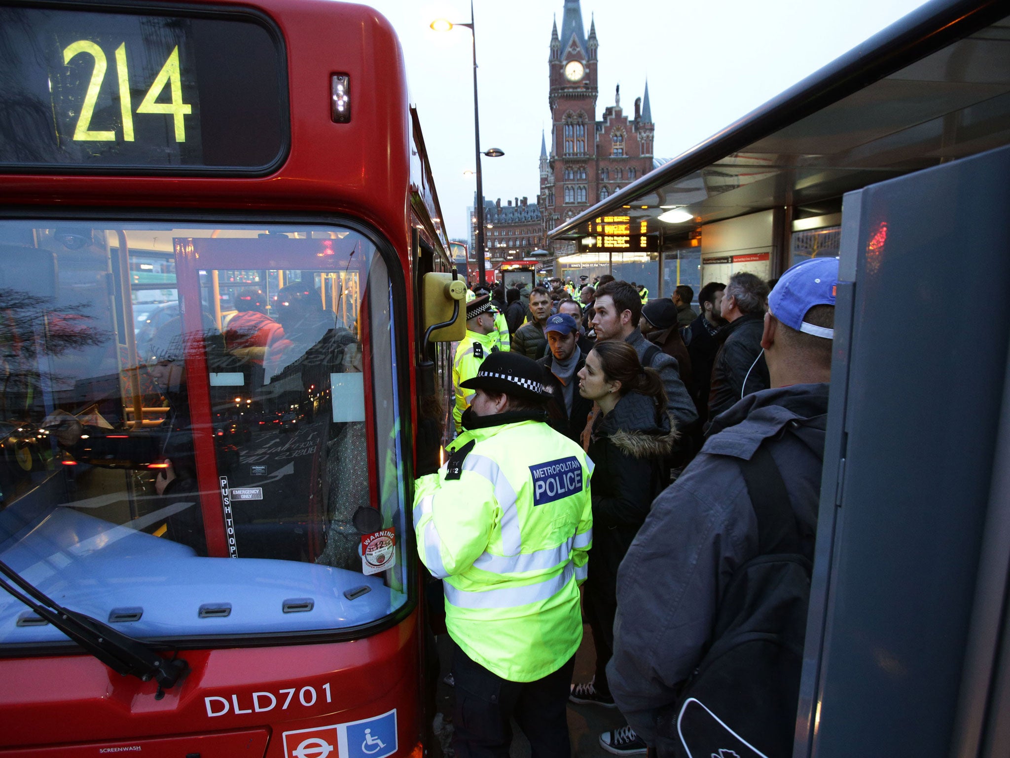 Commuters waiting at a bus stop at King's Cross station during the London Underground workers strike in 2014
