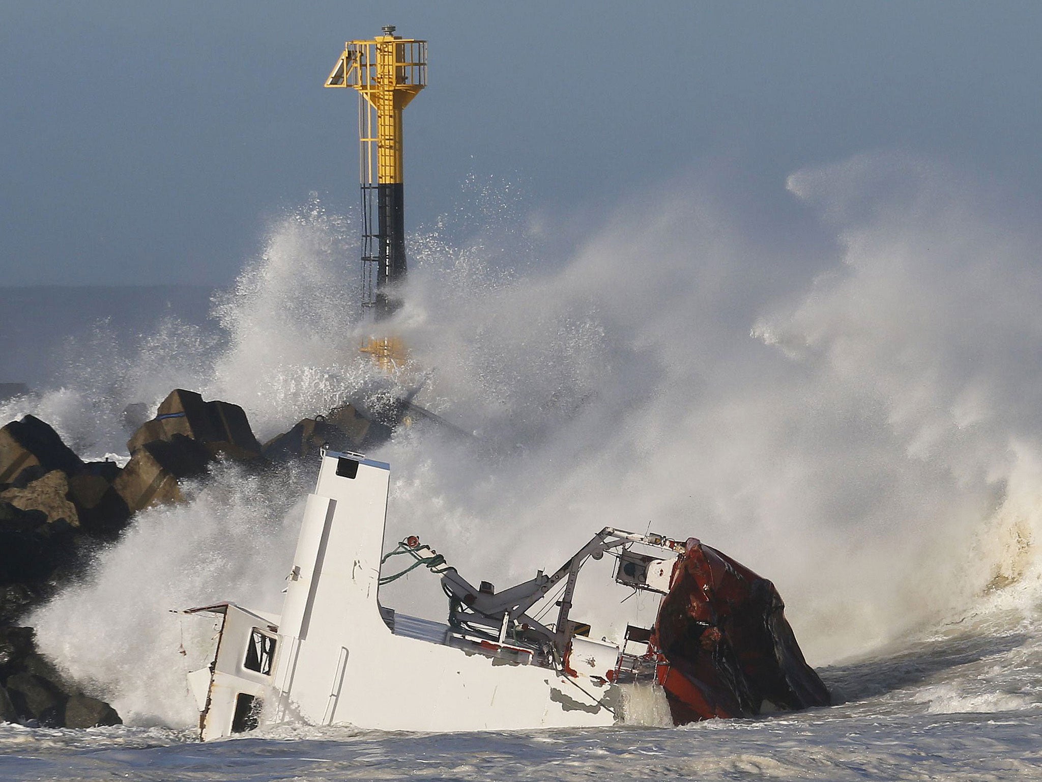 Waves are seen breaking against the Spanish cargo ship "Luno" the day after it broke in two on a seawall off the beach in Anglet on the Atlantic Coast of France