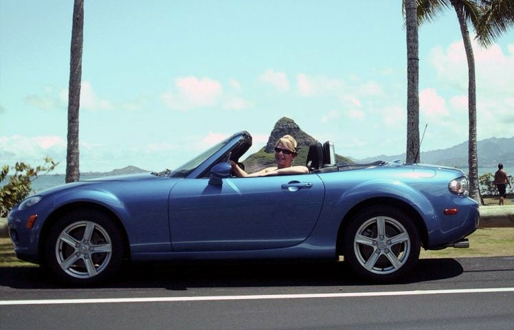 This 2006 photo shows Jennifer Jones in her Mazda Miata in Kaneohe, Hawaii. Jones, who stopped to help after a crash on a Honolulu freeway on Sunday says two men involved in the wreck stole her car, leaving behind an injured passenger.