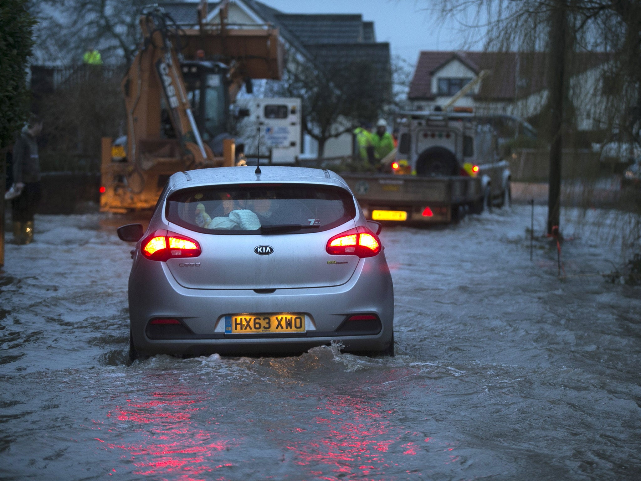 A car drives through rising flood waters as it leaves the village of Moorland on the Somerset Levels near Bridgwater