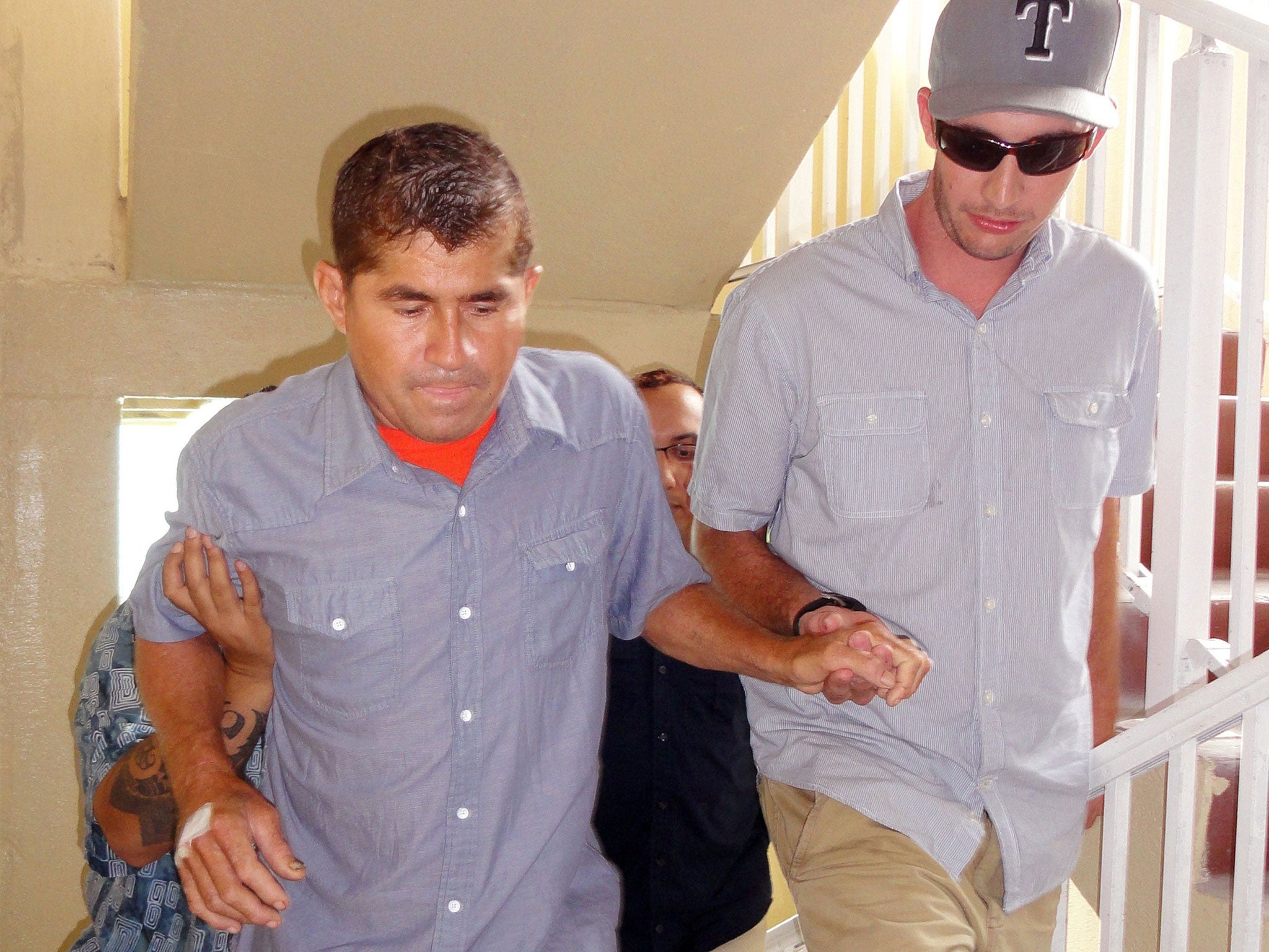 Pacific castaway Jose Salvador Alvarenga (L) is helped into a press conference in the Marshall Islands capital of Majuro on 6 February, 2014.