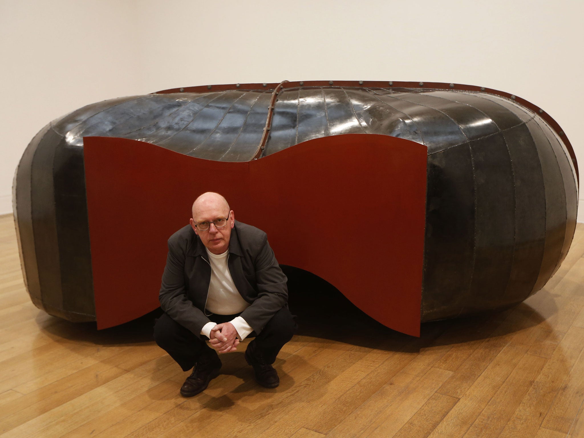 British artist and Turner Prize winner Richard Deacon poses with his sculpture 'Struck Dumb 1988' at Tate Britain