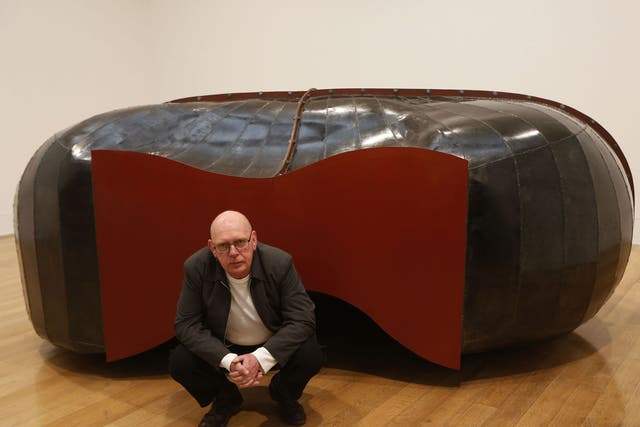 British artist and Turner Prize winner Richard Deacon poses with his sculpture 'Struck Dumb 1988' at Tate Britain