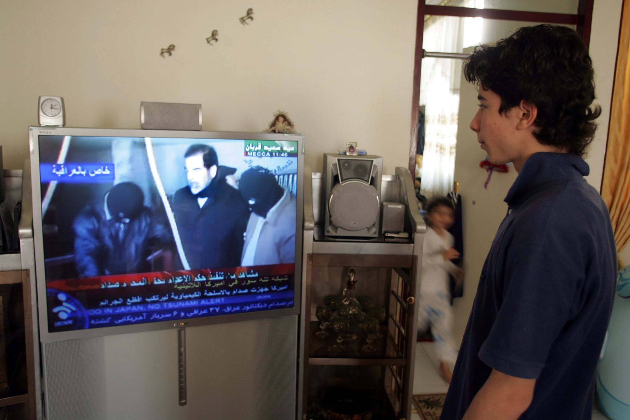 An Iranian youth watches footage of Saddam Hussein's execution on TV in 2006