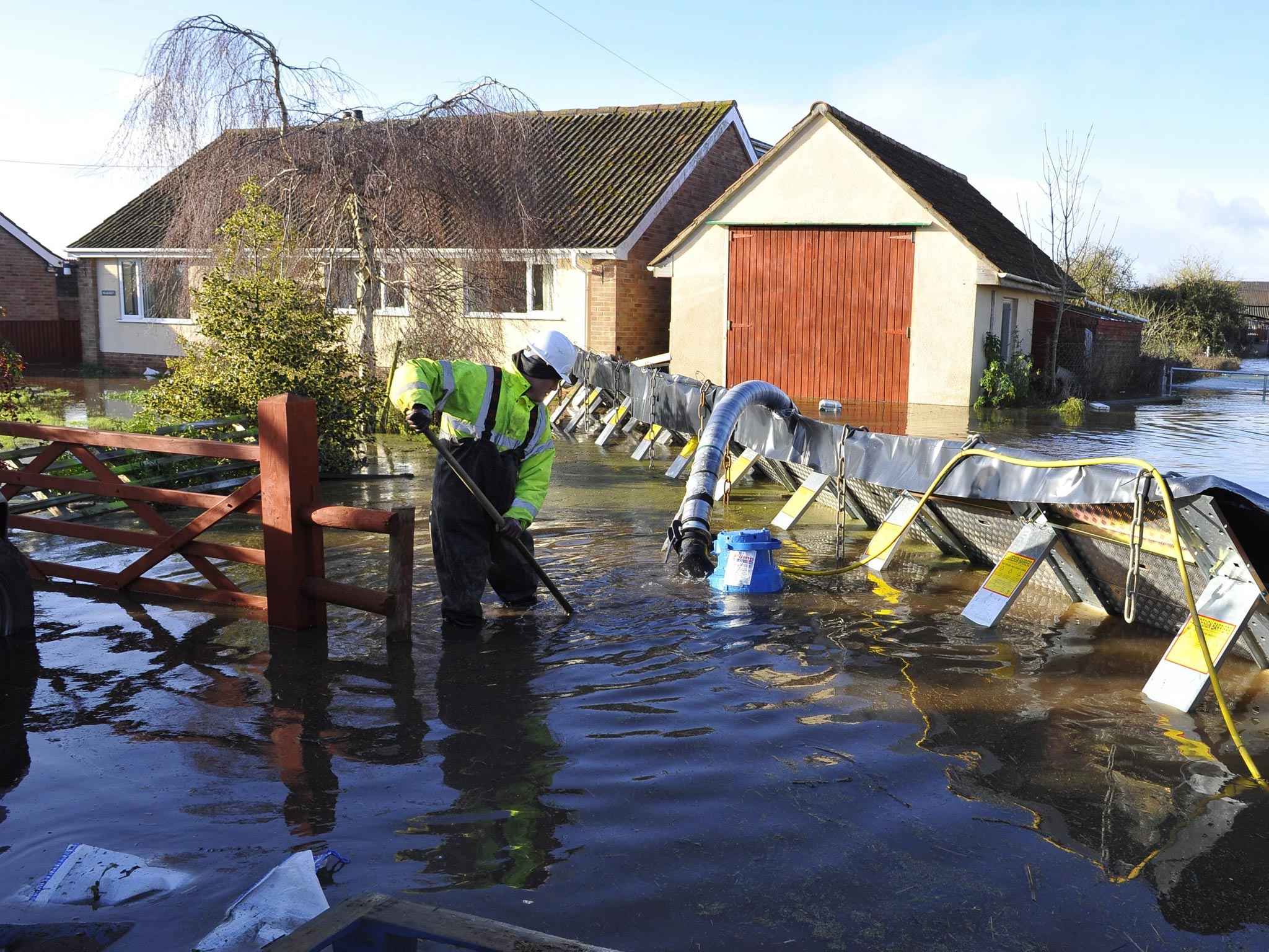 A member of the emergency services installing flood defences in the village of Moorland on the Somerset Level