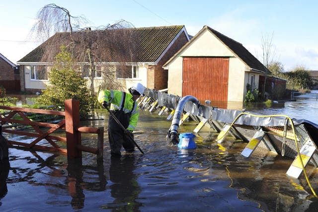 A member of the emergency services installing flood defences  in the village of Moorland on the Somerset Level