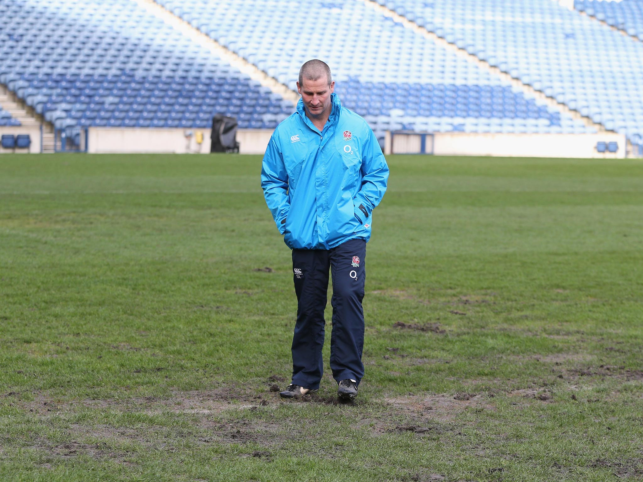 Stuart Lancaster, the England head coach inspects the pitch during the England captain's run at Murrayfield Stadium
