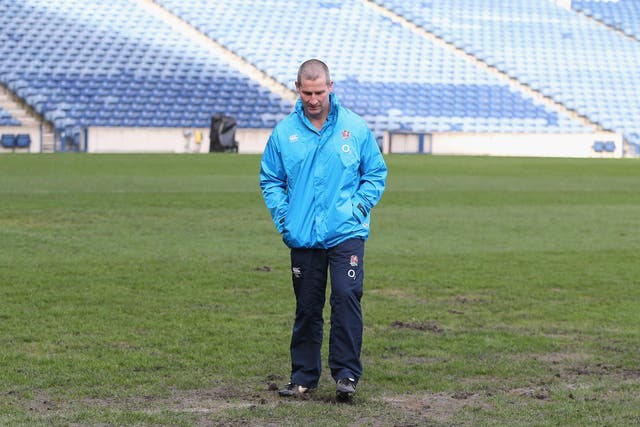 Stuart Lancaster, the England head coach inspects the pitch during the England captain's run at Murrayfield Stadium