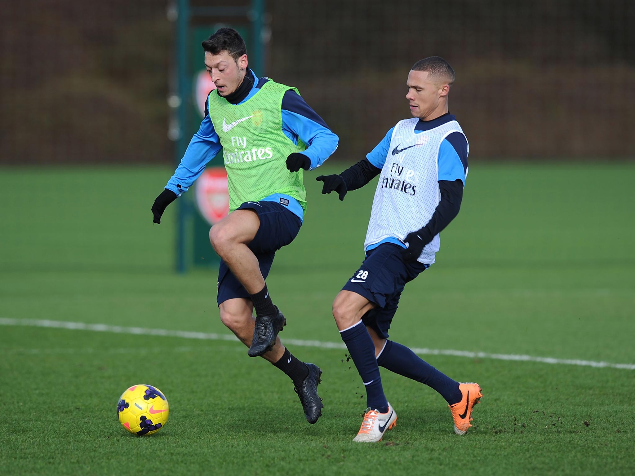 Mesut Özil (left) holds off Kieran Gibbs in training yesterday