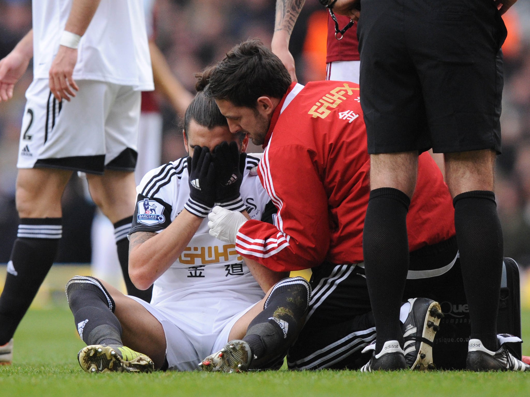 Chico Flores holds his face after a clash with Andy Carroll during West Ham's match against Swansea