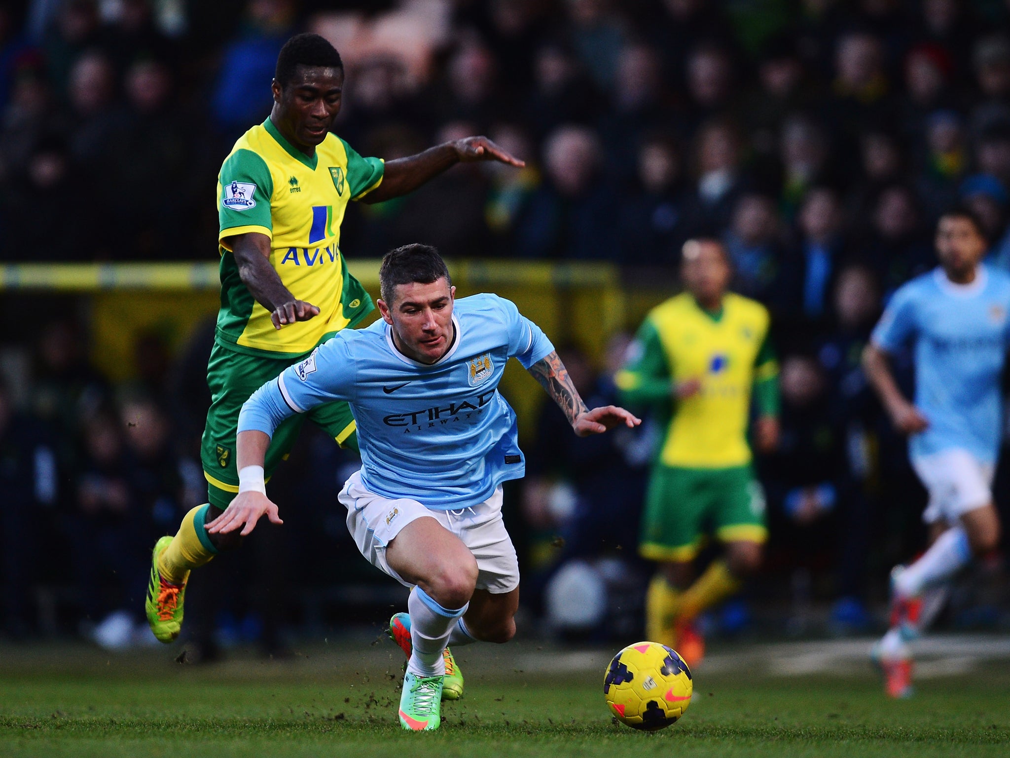 Manchester City defender Aleksandar Kolarov falls to the under pressure from Norwich midfielder Alexander Tettey