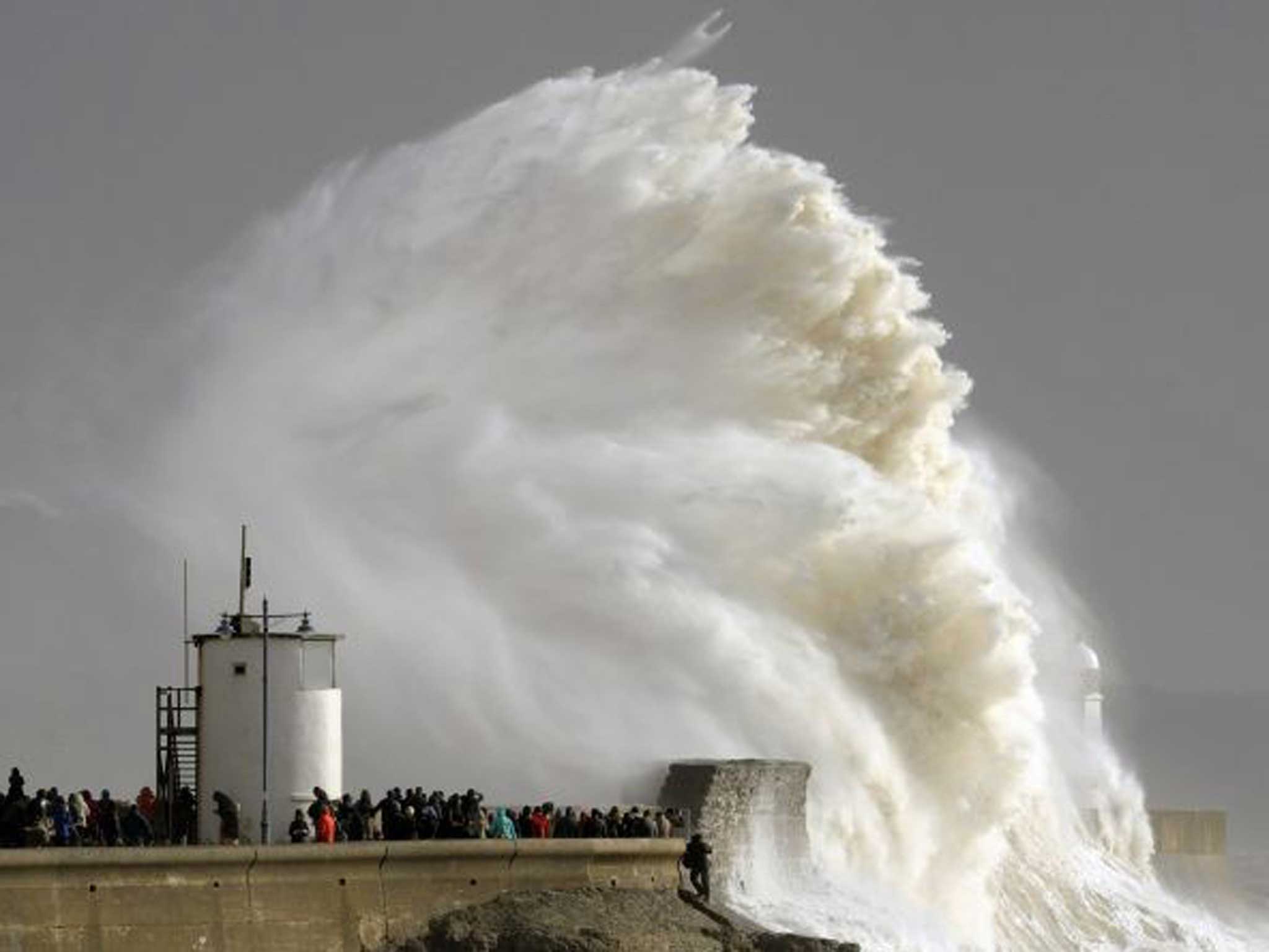 In danger: Bystanders in Porthcawl, South Wales, watch the giant waves