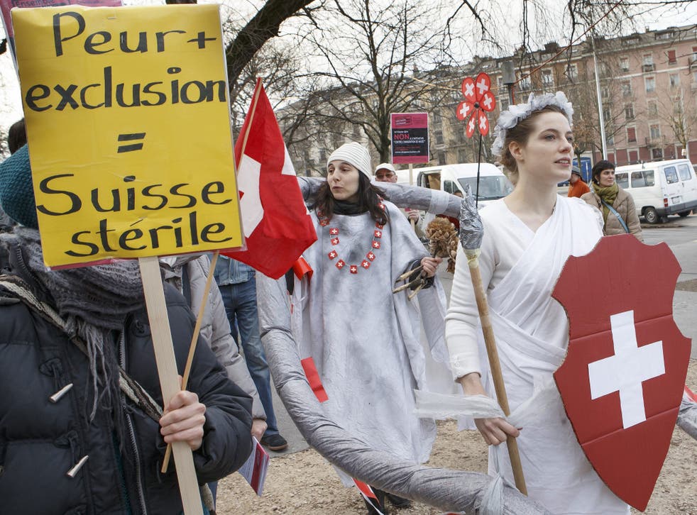 A file picture showing protests last month against the anti-immigration referendum, with a panel reading 'fear + exclusion = sterile Switzerland'. Swiss citizens have now voted in favour of the proposals brought by a right wing populist party