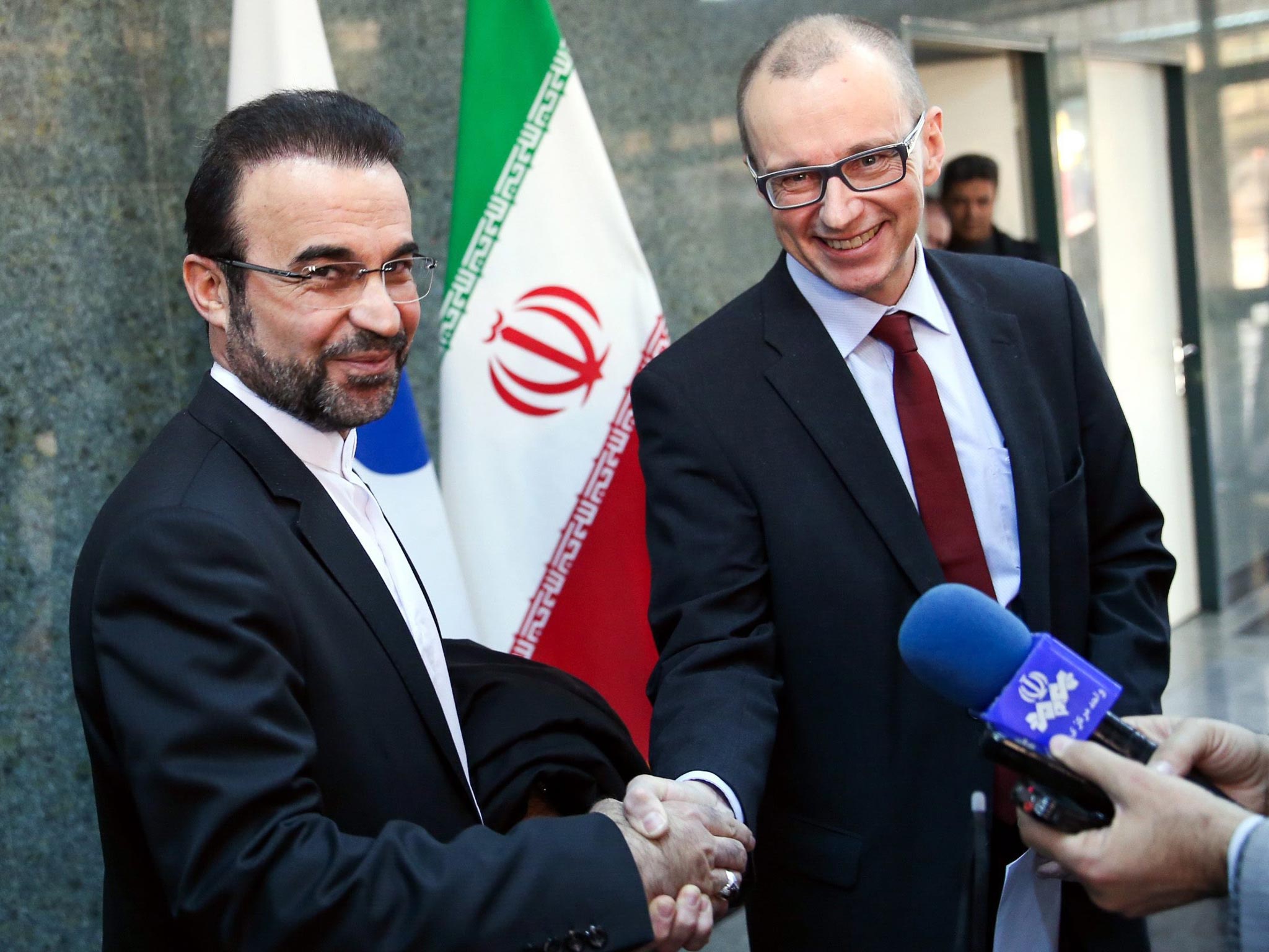 The deputy head of the International Atomic Energy Agency (IAEA), Tero Varjoranta (R), and Iranís IAEA envoy Reza Najafi (L) shake hands after an agreement reached, in Tehran, Iran