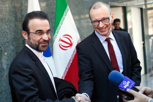 The deputy head of the International Atomic Energy Agency (IAEA), Tero Varjoranta (R), and Iranís IAEA envoy Reza Najafi (L) shake hands after an agreement reached, in Tehran, Iran