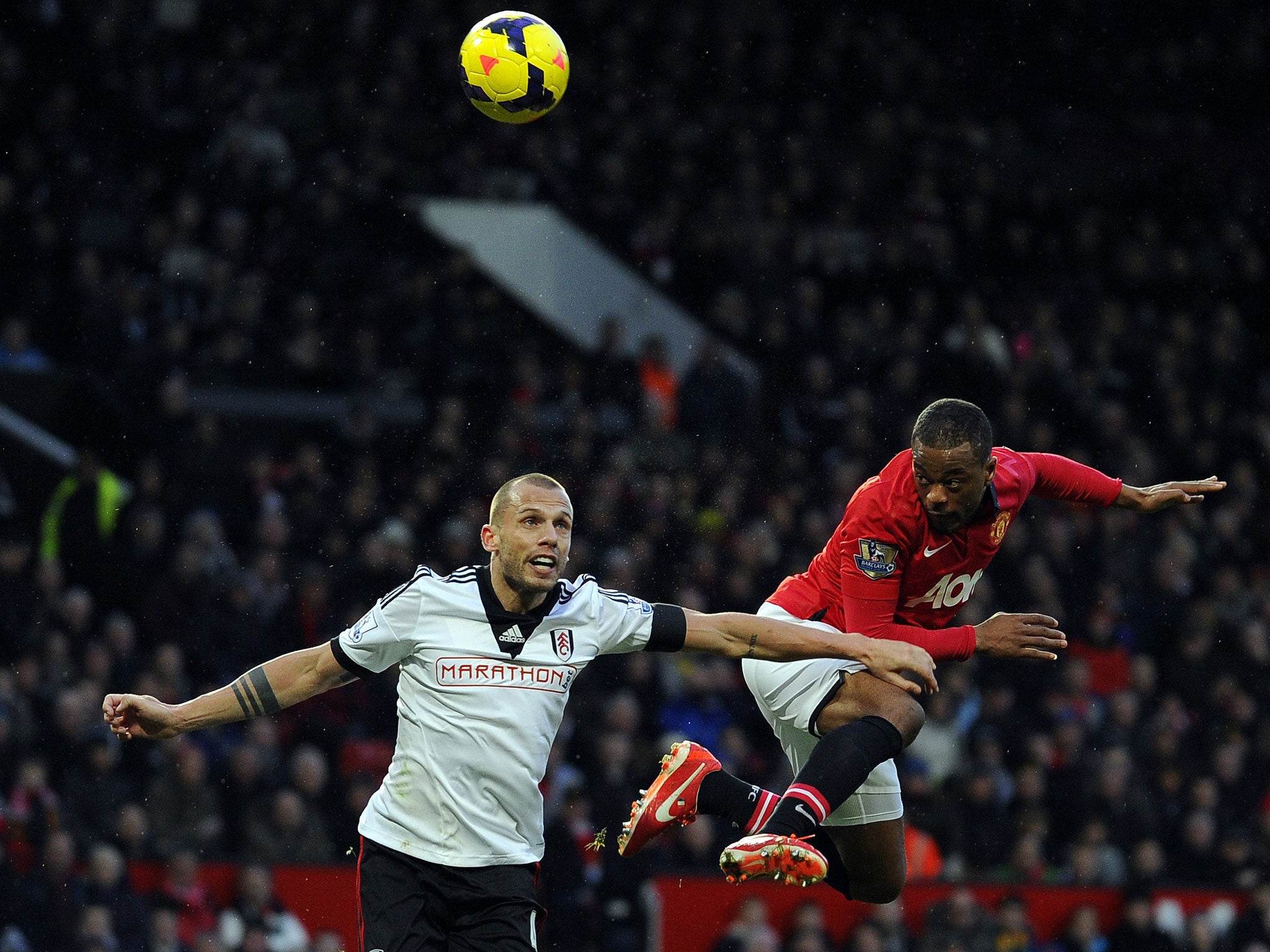 Fulham's Dutch defender John Heitinga, left, and Manchester United's French defender Patrice Evra, right, compete for the ball