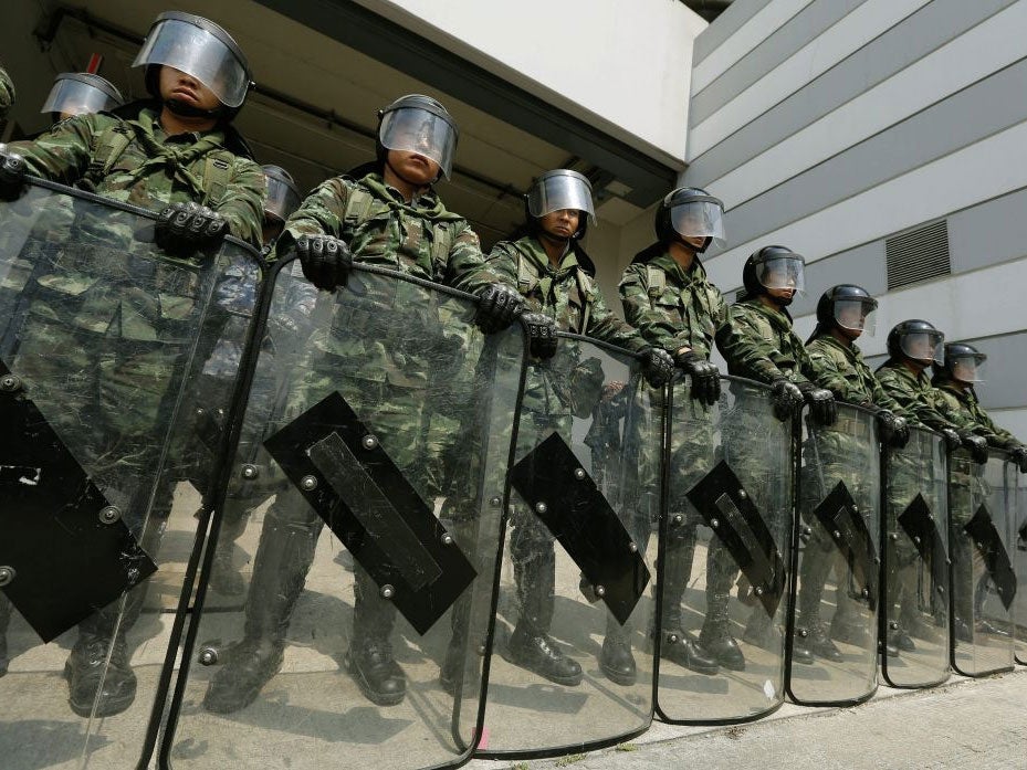Thai Army soldiers stand guard in front of the temporary office of the cabinet of interim Prime Minister Yingluck Shinawatra, in Bangkok