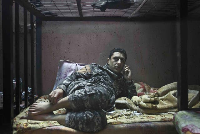 No rest for those who hunt the wicked: Ali, a member of The Hawks, sits on his bunk bed while on stand-by at the team’s barracks in Baghdad