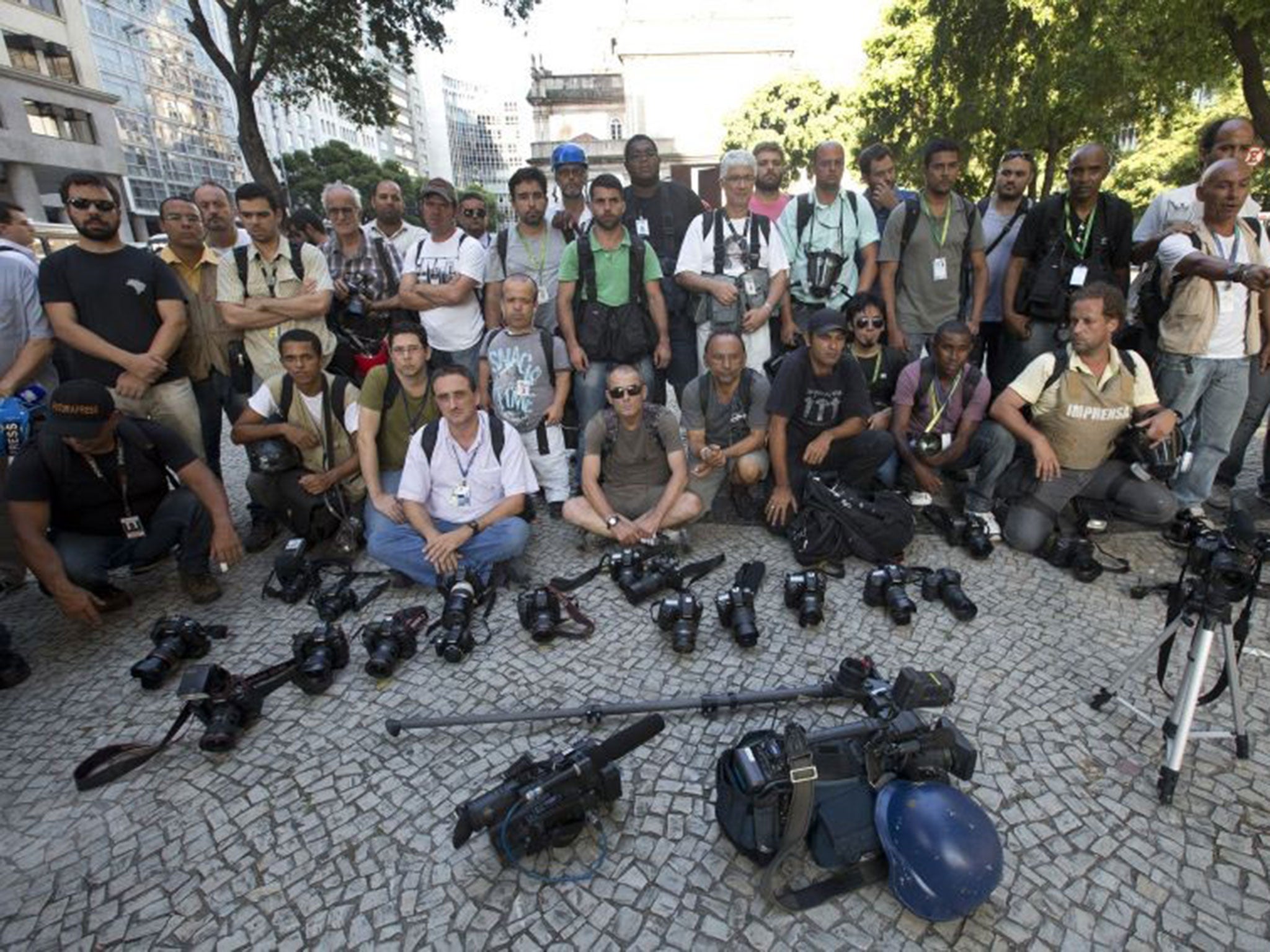 Journalists put their cameras down for one minute, in tribute to Santiago Andrade, who has been declared brain-dead after being injured by a flare in Thursday's violence