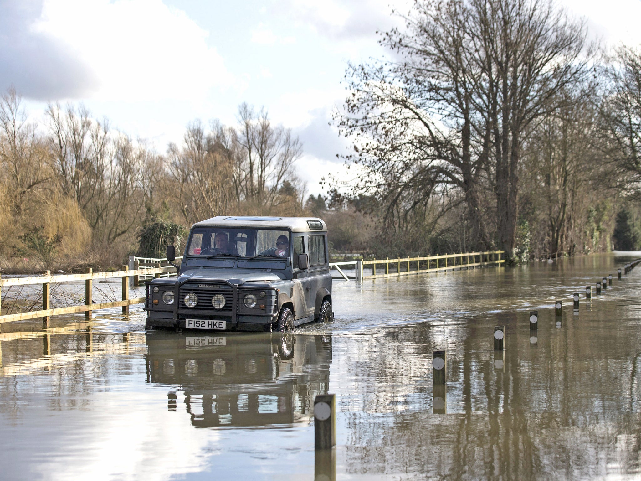 A Land Rover drives along a flooded street in Shepperton (Getty)