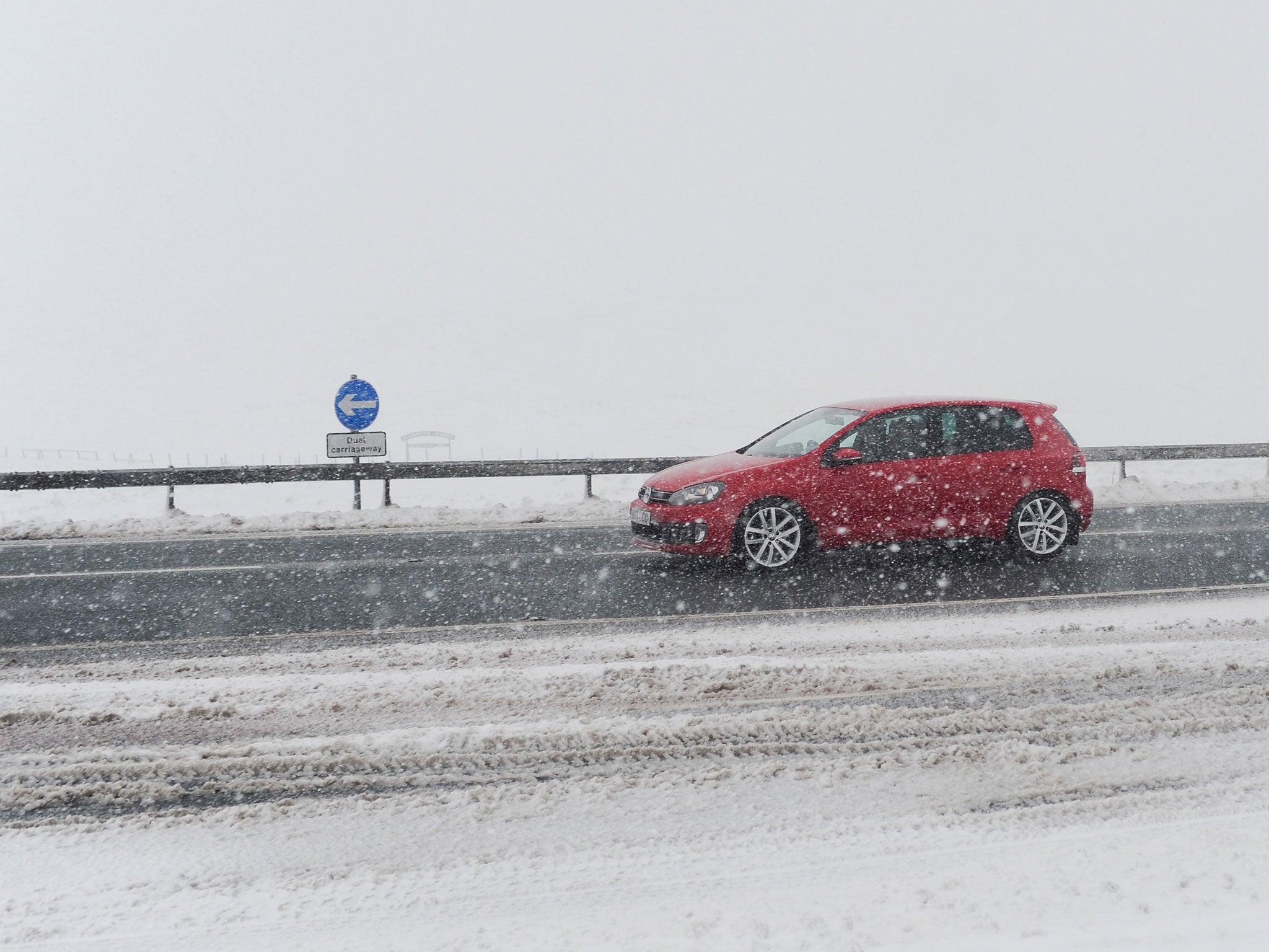 A motorist drives in snowy conditions.