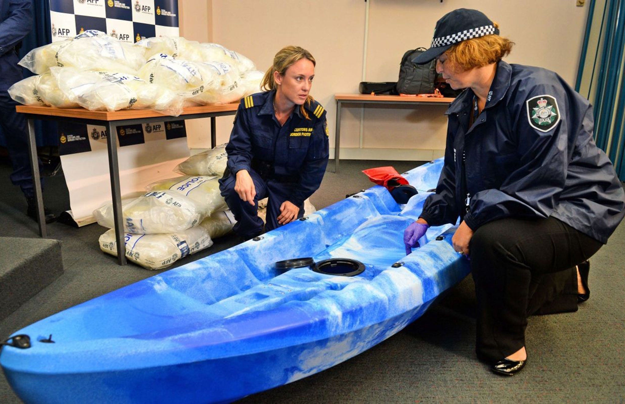 An Australian Customs officer and an Australian Federal Police officer inspect one of the 27 kayaks seized
