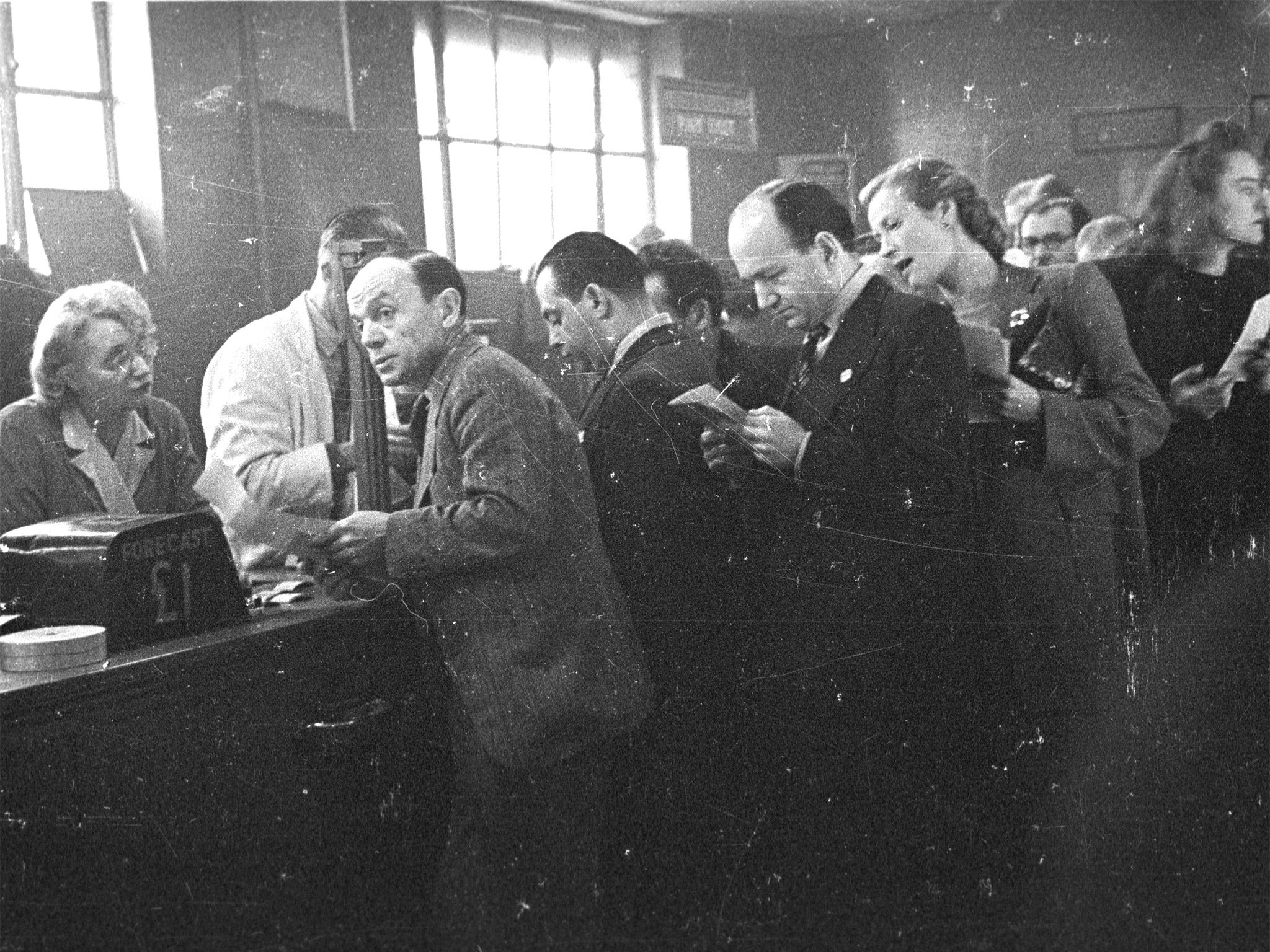 Guessing game: punters line up to place bets the old-fashioned way at London’s White City Greyhound Racing Stadium in 1943