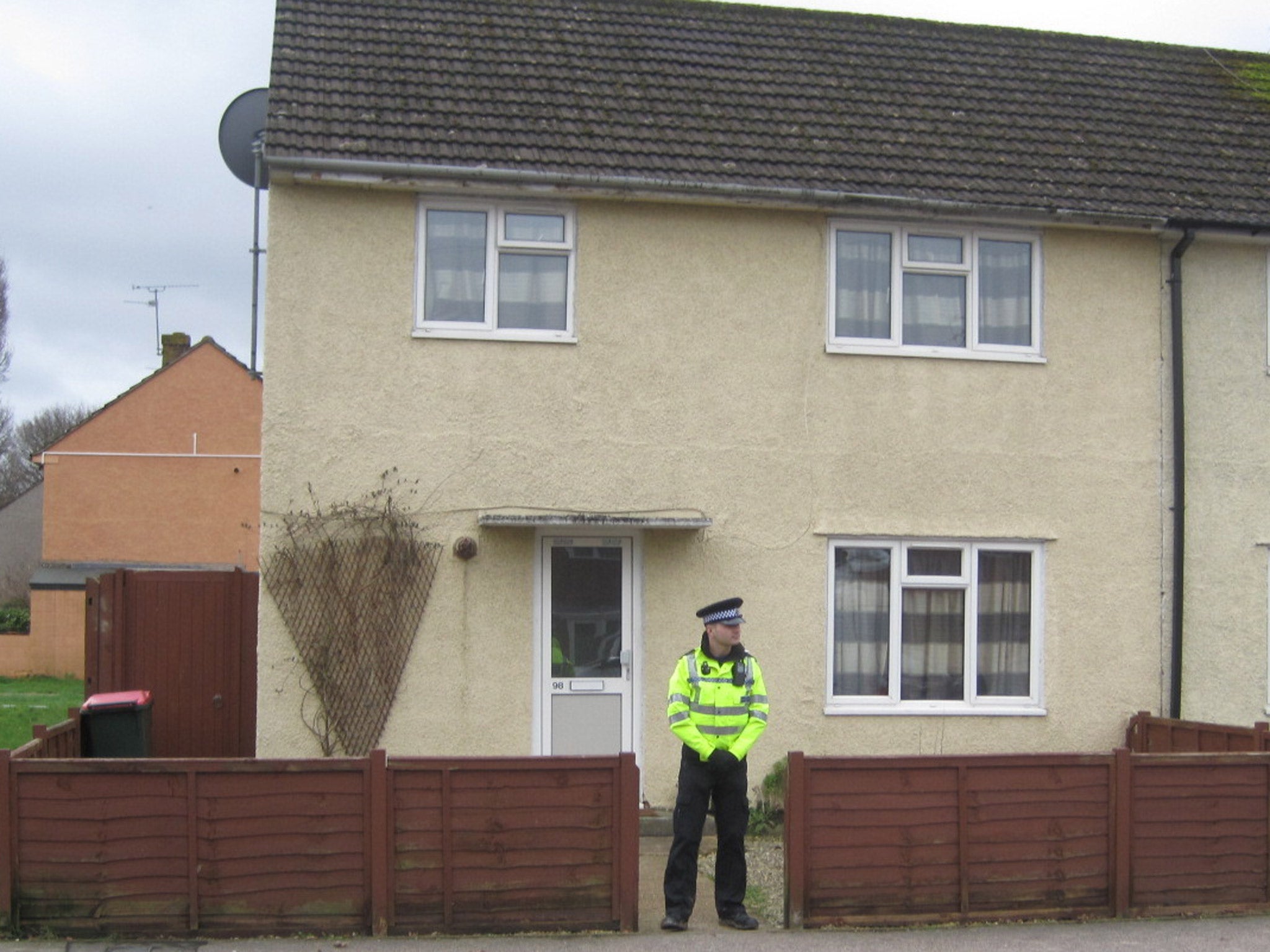 A policeman guards the house in Crawley