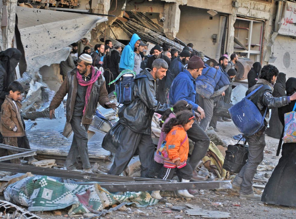 Syrian civilians are evacuated during a humanitarian operation in the besieged city of Homs