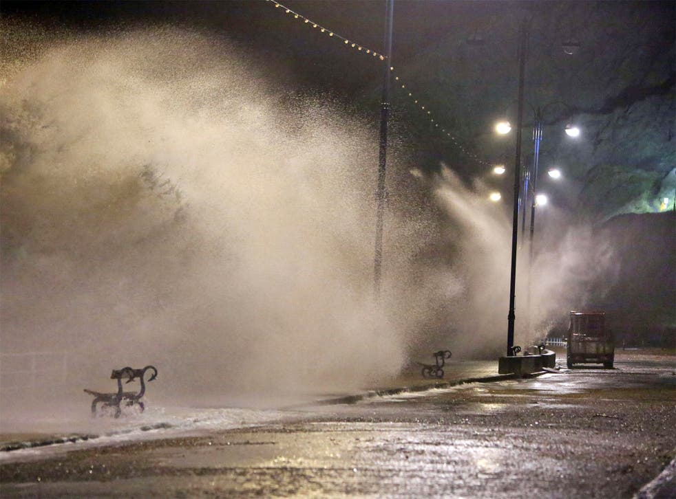 Waves break over the sea wall in Aberystwyth, west Wales