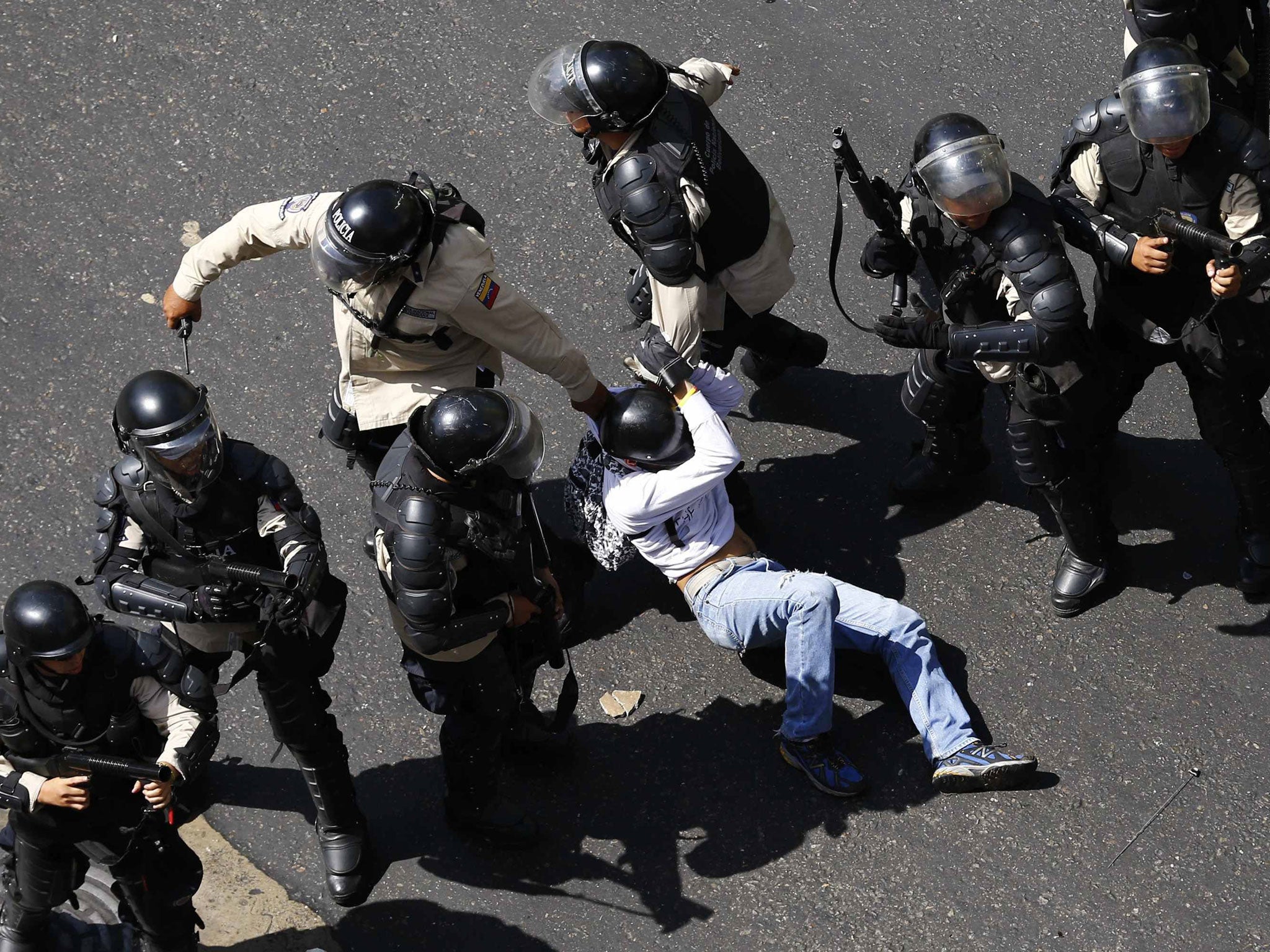 A demonstrator is detained after jumping over a riot police line during an anti-government protest in Caracas