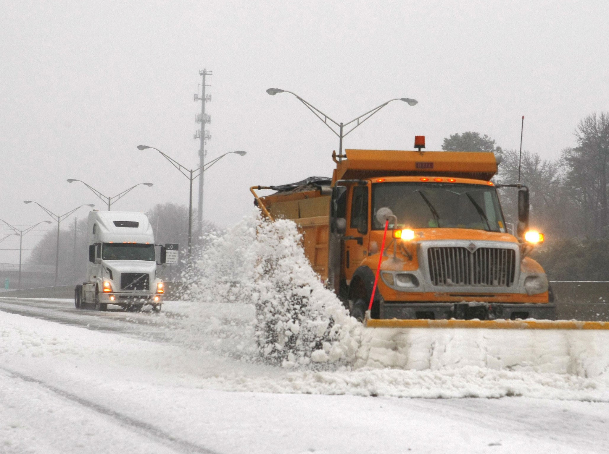A snow plow knocks snow off the an Atlanta expressway during an ice storm in Atlanta, Georgia, February 12, 2014