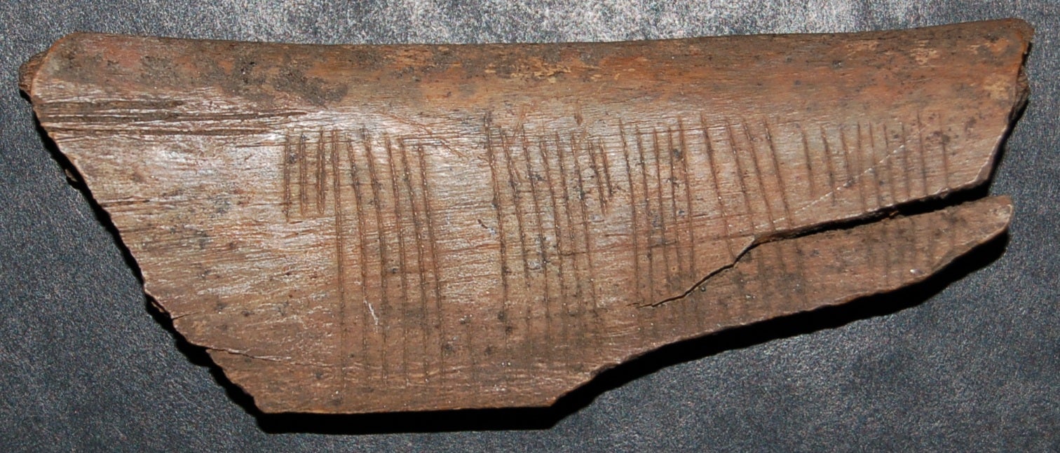The wooden stick that shows the jötunvillur code and the 'Kiss me' message.