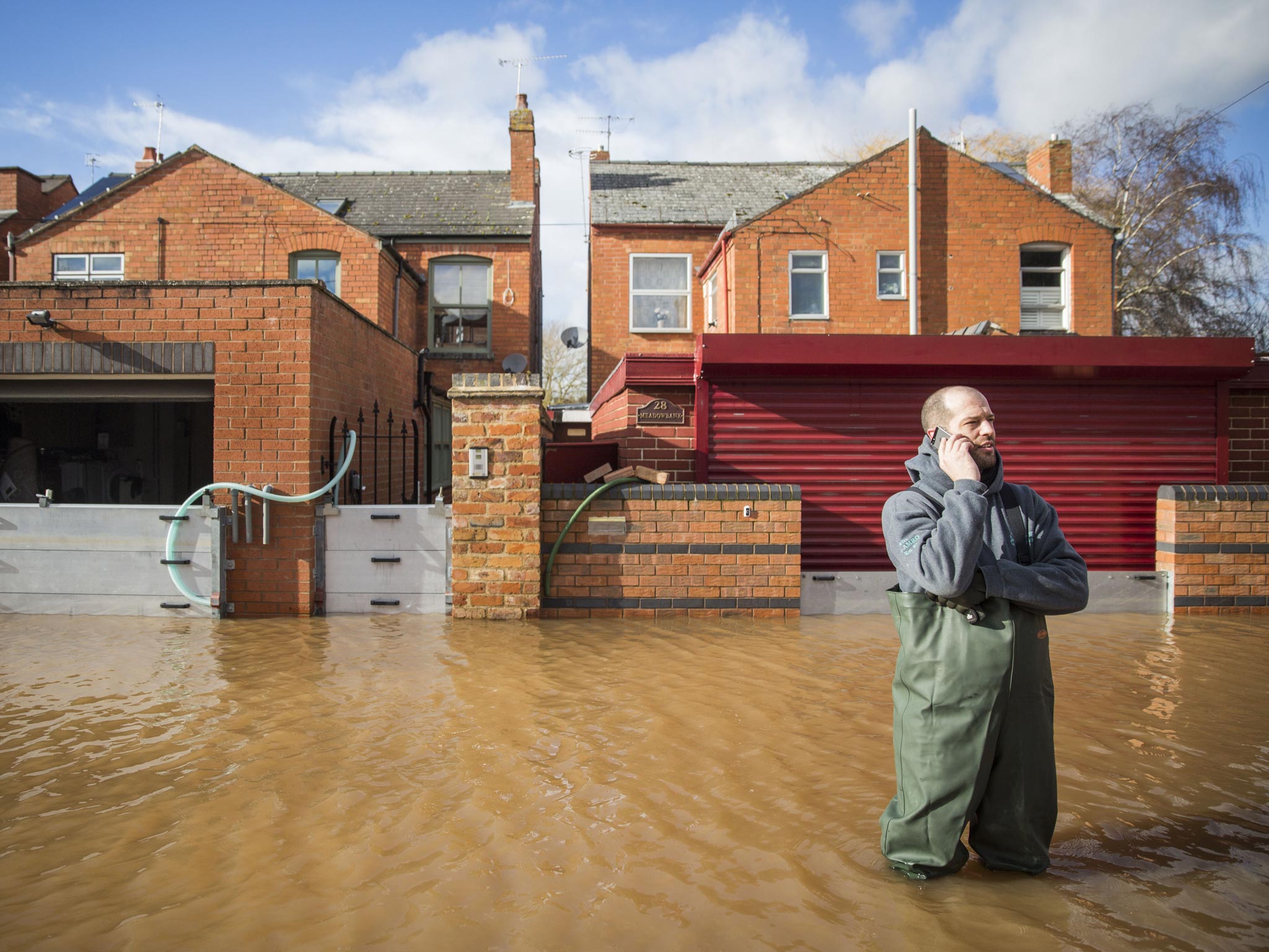 A resident of Waterworks Road stands in floodwater in Worcester