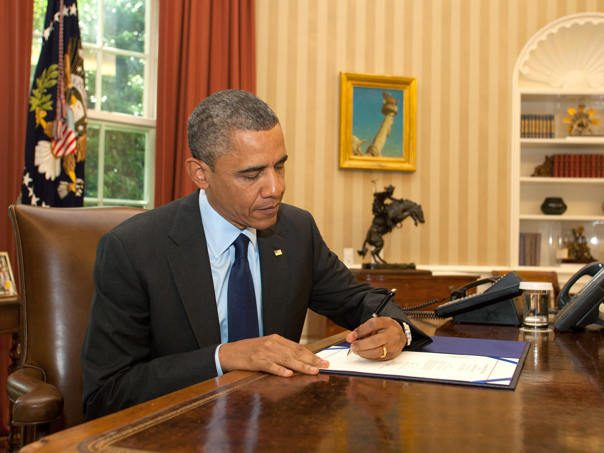 The president at his desk in the White House Oval Office