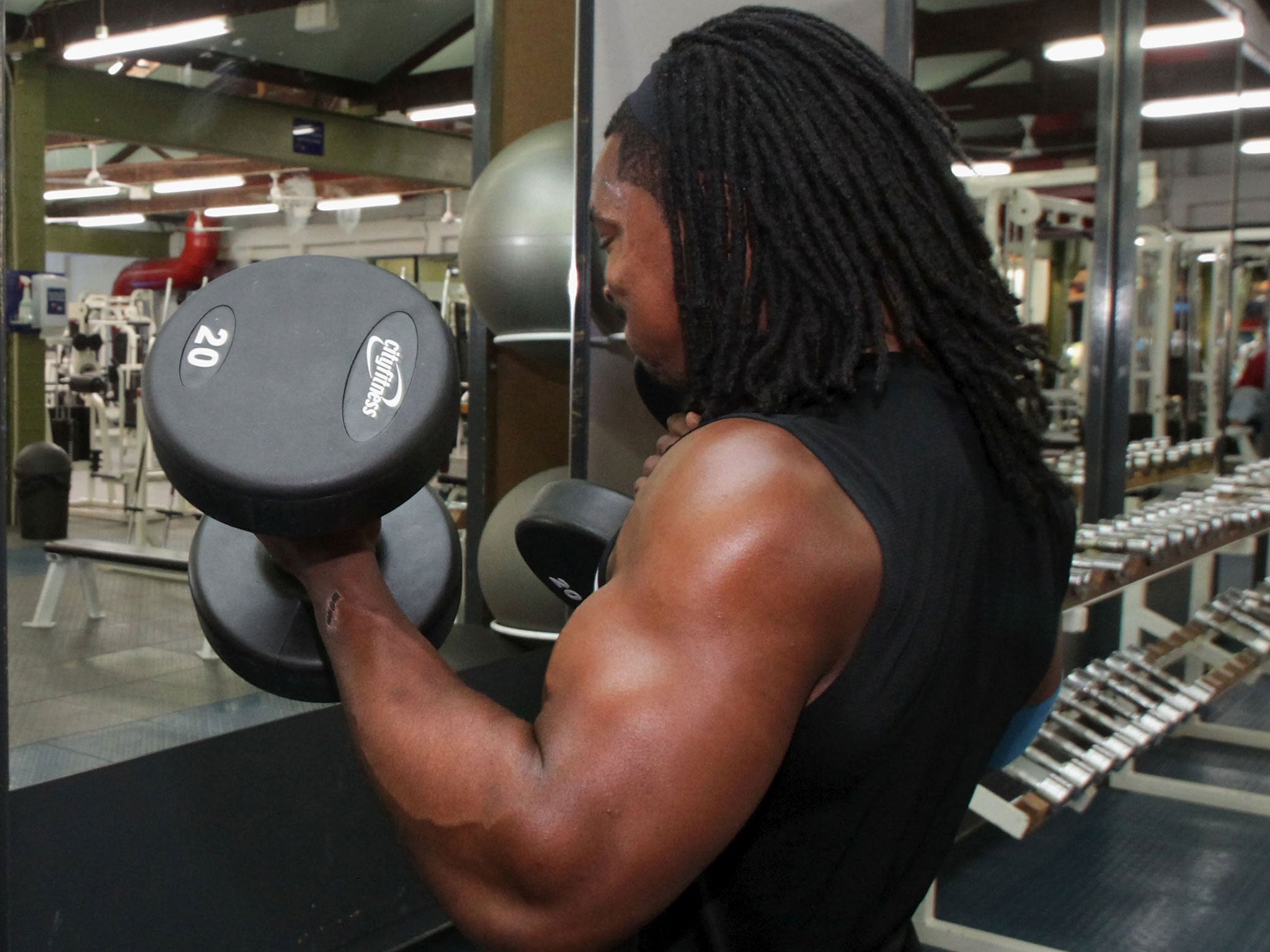 A man lifts weights in New Zealand. Researchers have found that people less inclined to exercise may be affected by a mutated gene