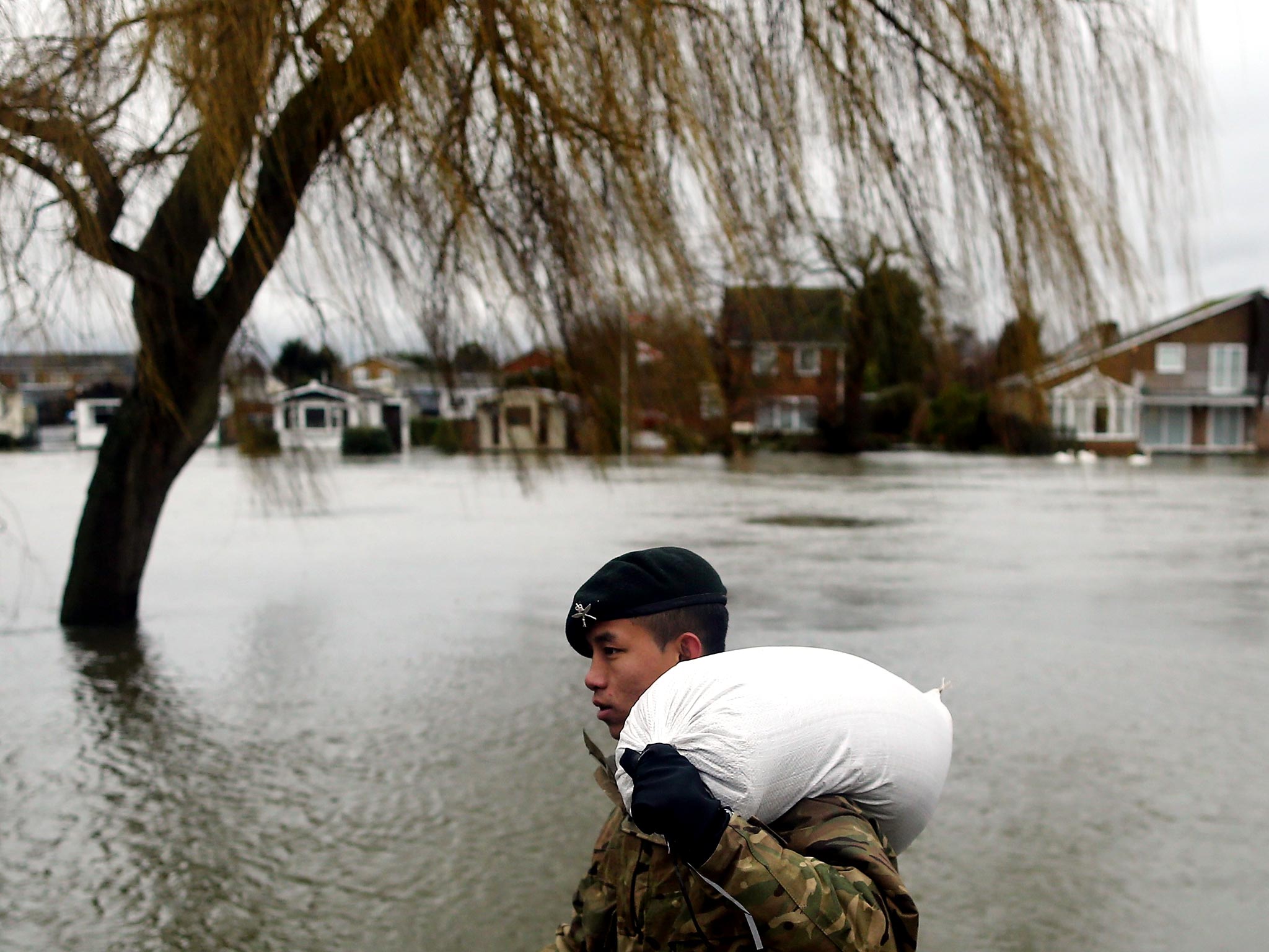A Gurkha helps to place sandbags outside homes along the Thames
in Staines yesterday