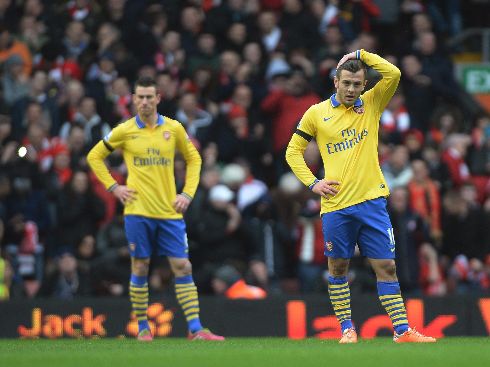 Arsenal’s Jack Wilshere (right) and Laurent Koscielny show their
frustration during the defeat at Anfield
