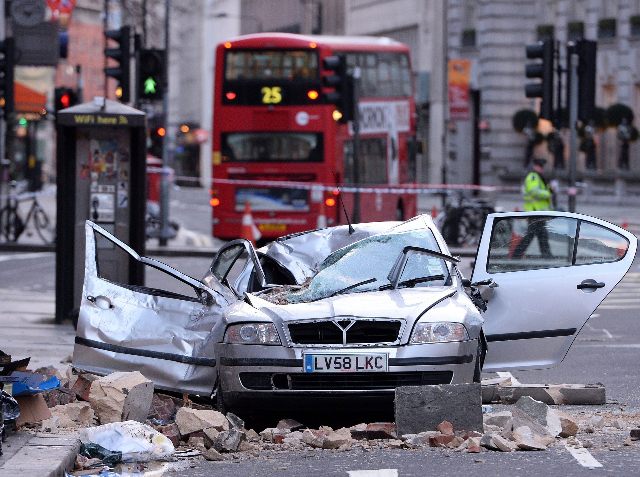 Rubble surrounds a damaged car after parts of a building collapsed onto the vehicle, killing a woman in central London, Britain, early 15 February 2014.