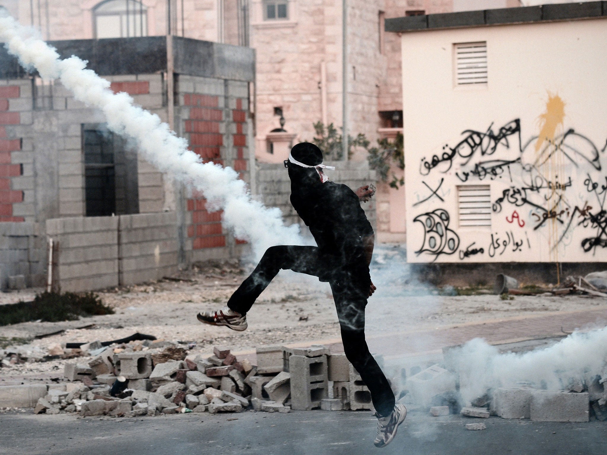 A Bahraini protester clashes with riot police following the funeral of 20-year-old prisoner Fadel Abbas Musalem in the village of Diraz on January 26, 2014