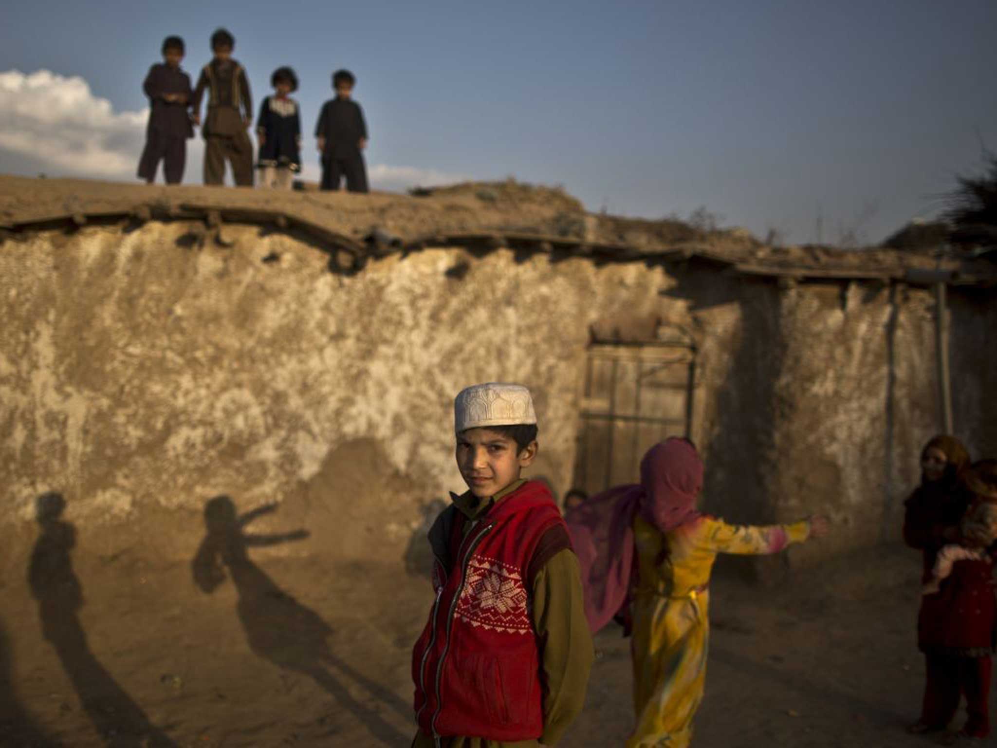 Far from Home: Afghan refugee children play on a rooftop on the outskirts of Islamabad